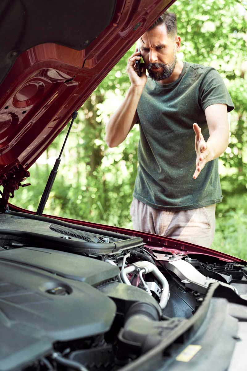 Junger Mann prüft Getriebeschaden bei Schrottauto Ankauf Viersen